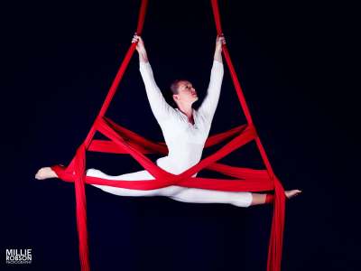 Aerial silk circus performer for hire. Our UK-based acrobatic aerialist is available to book for product launches & corporate events.