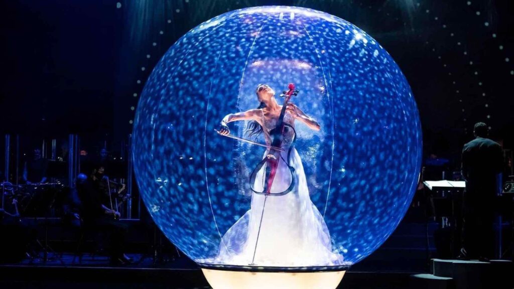 Cello musician performing stage show inside bubble