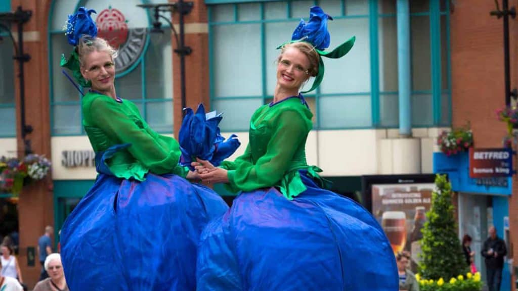 Flower Stilt Walkers performing at a shopping centre in the UK.
