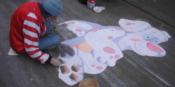 Artist-Drawing-Cartoon-In-Chalk