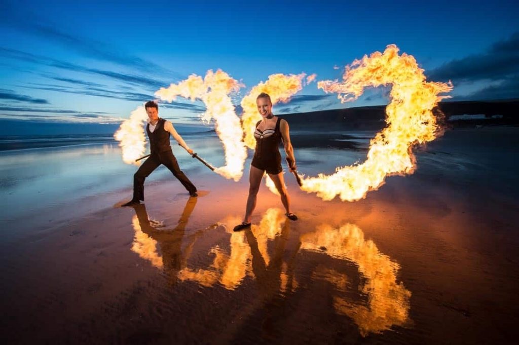 Blaze Fire Dancers performing a fire show on a beach in the UK. Our fire dancers are available to book for events in the UK.
