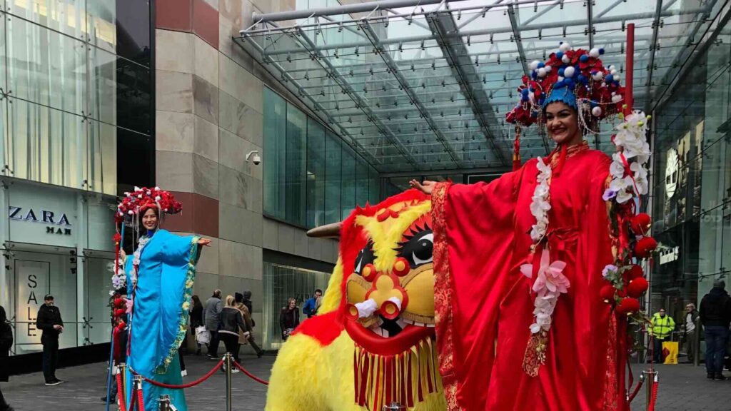 Chinese stilt walker with dragon dancer