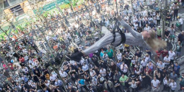 Wall-Acrobat-Hanging-Over-Crowd