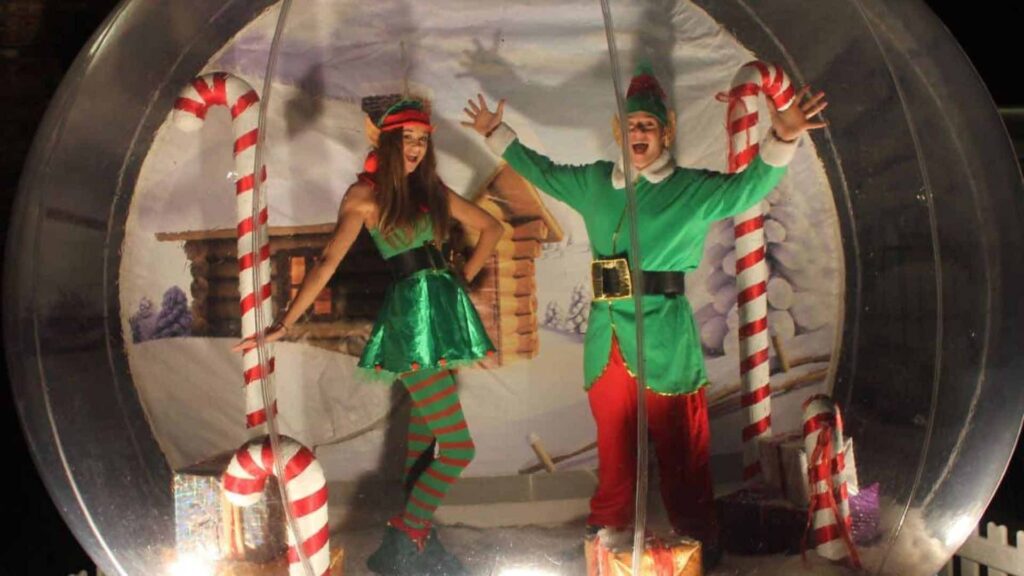 Performers dressed as elves inside Christmas photo booth
