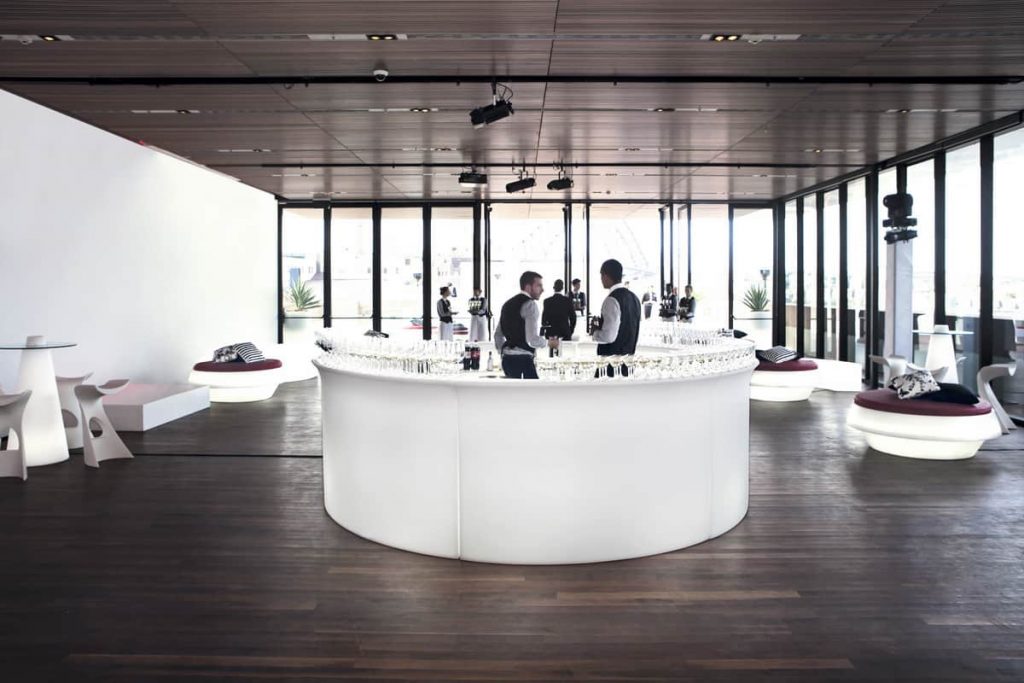 Circular white LED Bar with bartenders in the middle.