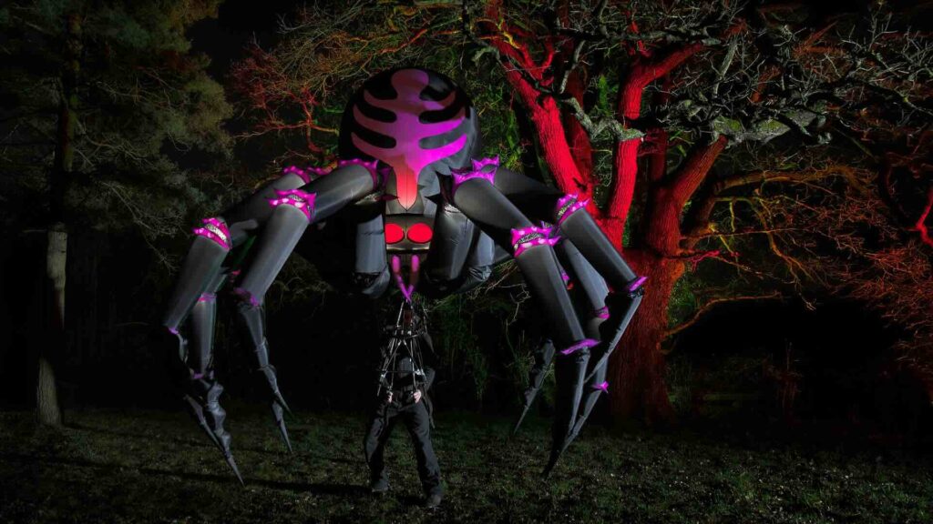 A giant spider walkabout act at an outdoor company event.