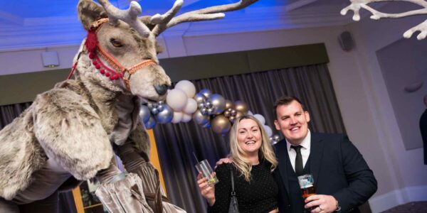 Guests-Posing-With-Reindeer-Stilt-Walkers