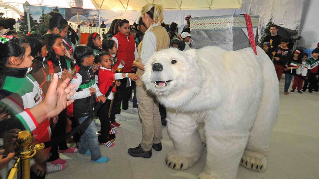 Children interacting with animatronic polar bear at shopping centre.