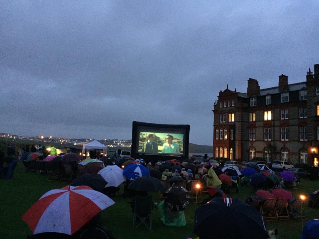 Large cinema screen in front of guests at pop up open air cinema event.
