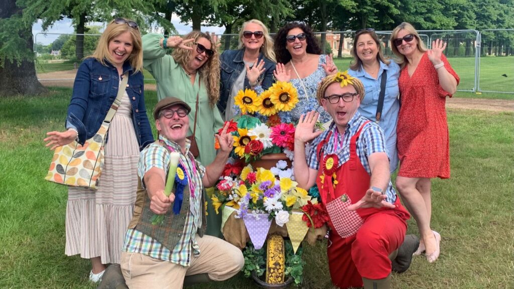 The avid gardeners posing with crowds of people at an outdoor event.