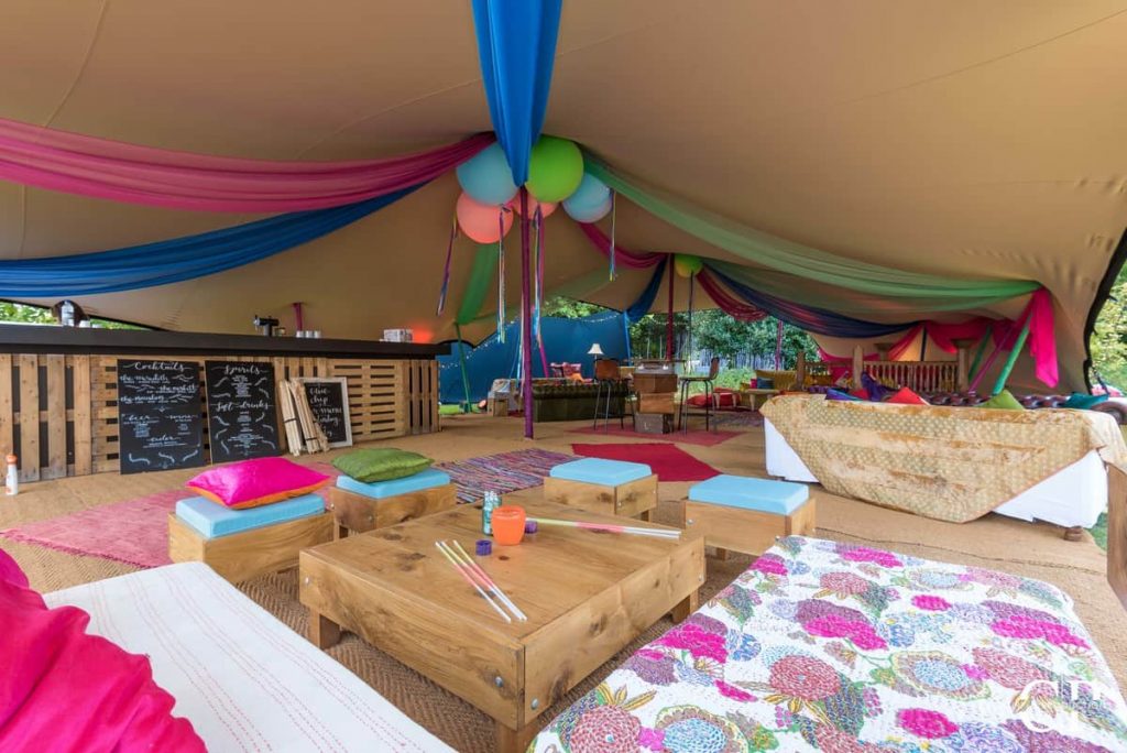 Summer Festival tent with pallet furniture, draping and more created by our event decorators.