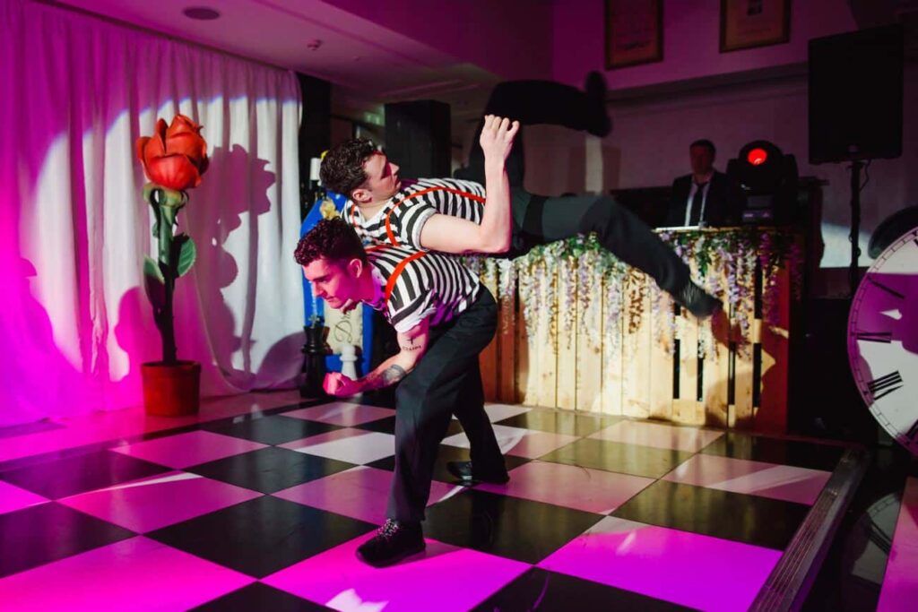 Twisted Alice In Wonderland staff party dance duo performing on stage.