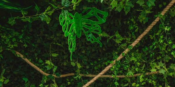 Green butterfly prop hanging from the ceiling of a jungle themed event.