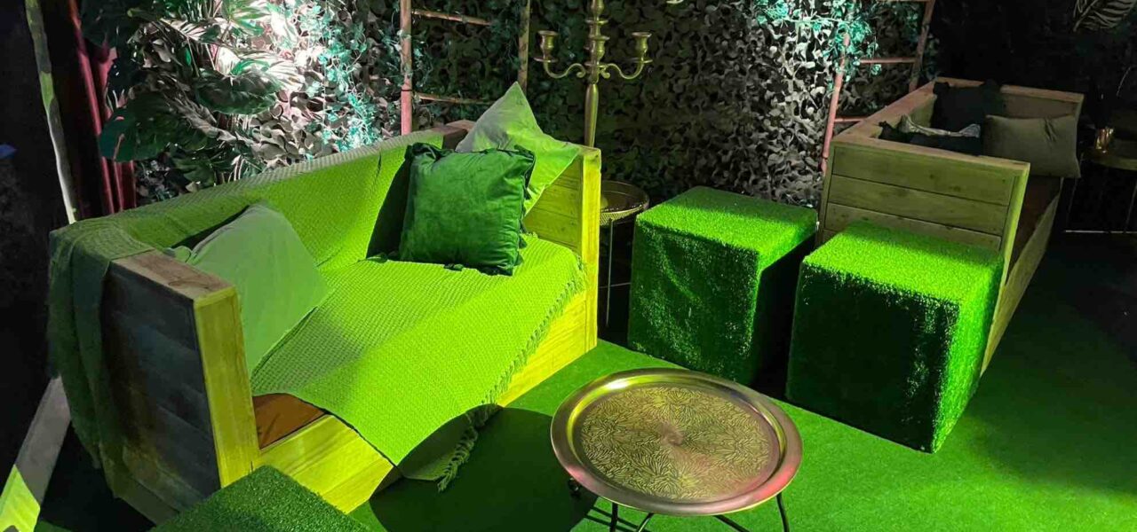 Creative bright green jungle themed seating area at corporate event.