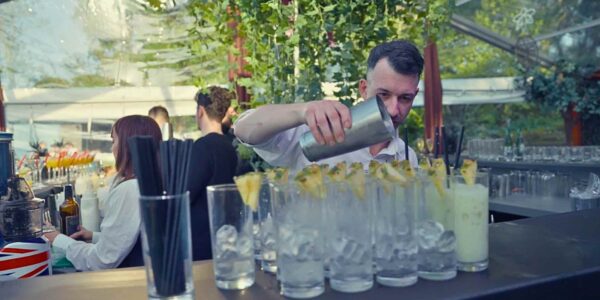 Tropical drinks being made and served by bartender at a jungle themed event.