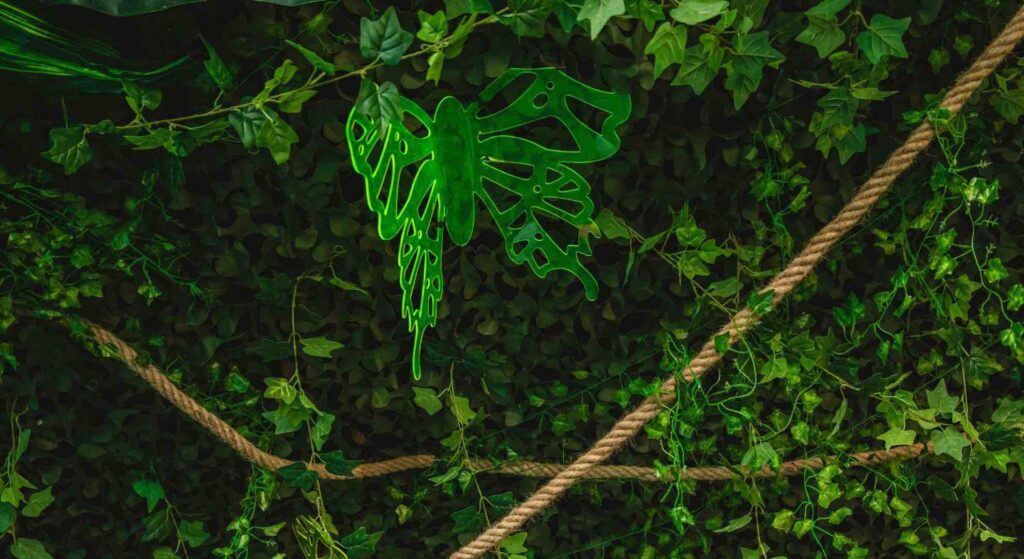Green butterfly prop hanging from the ceiling of a jungle themed event.