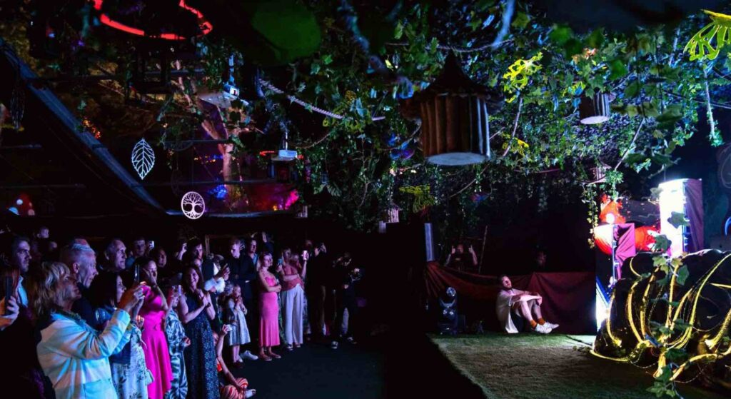 Guests clapping at performers on stage at a jungle event theme.