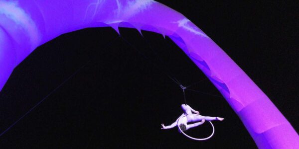 Acrobatic-Aerial-Entertainer-Hangs-From-Inflatable-Arch