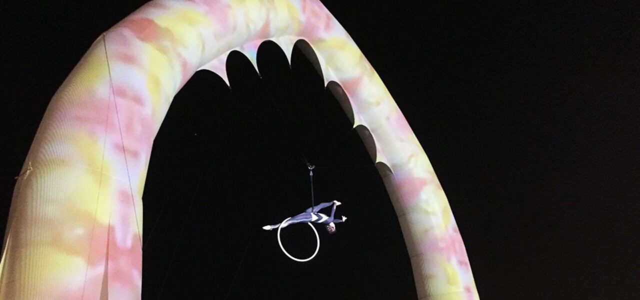 Aerialist-Hoop-Performer-Hanging-From-Colourful-Archway