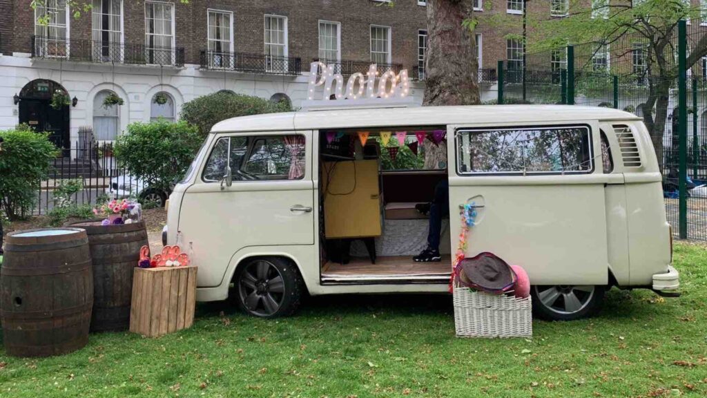 White camper-van photobooth with boxes of props sitting outside, an ideal summer event idea for photo opportunities.