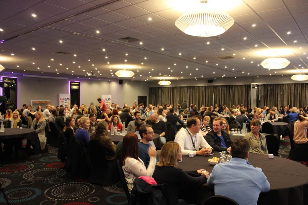 Employees sat at round tables at conference.