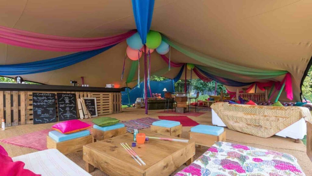 Marquee tent decorated with balloons and colourful cushions for a corporate festival.