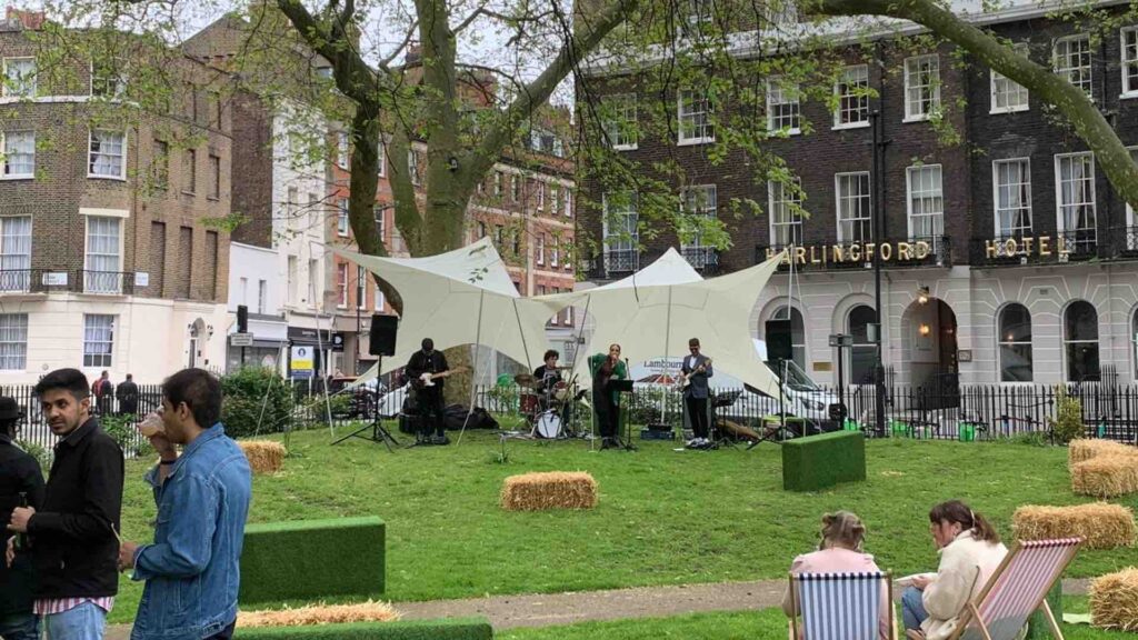 Band setting up under marquee structures set-up in park area