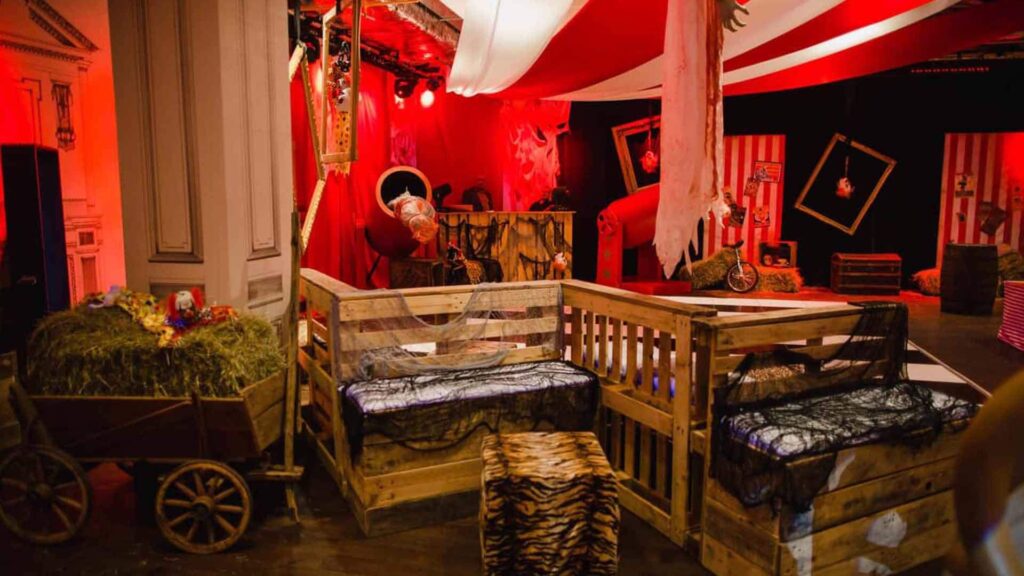 Pallet furniture decorated to look like opened cages for circus themed Halloween experience