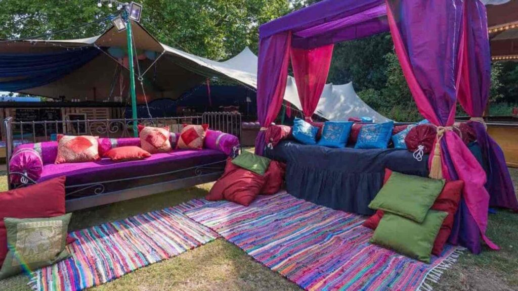 Colourful drapery and carpets placed at outdoor venue to create seating spaces for guests