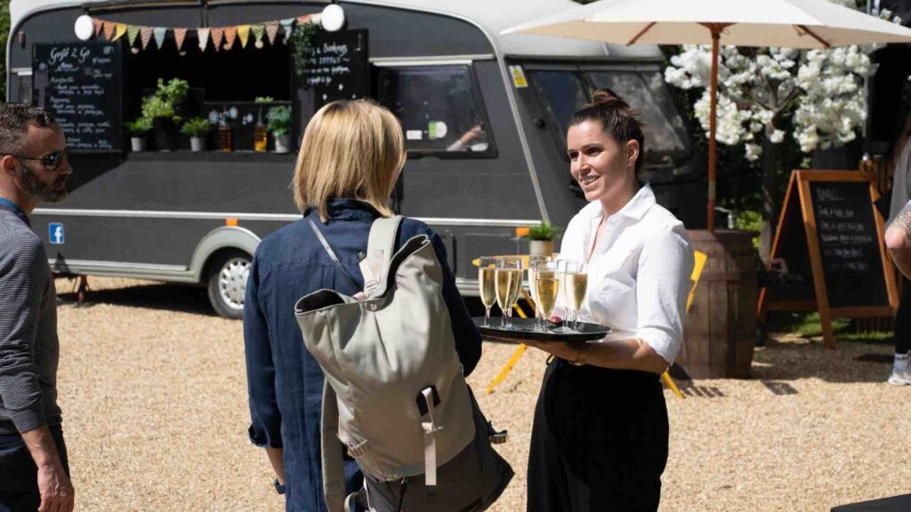 Guest taking to catering staff at entrance to festival event