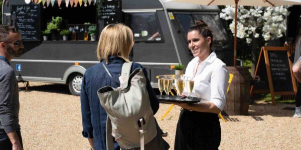 Waitress-Handing-Drinks-To-Guests