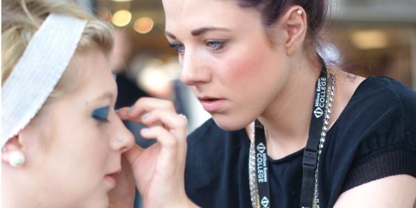 Makeup artist prepping catwalk model