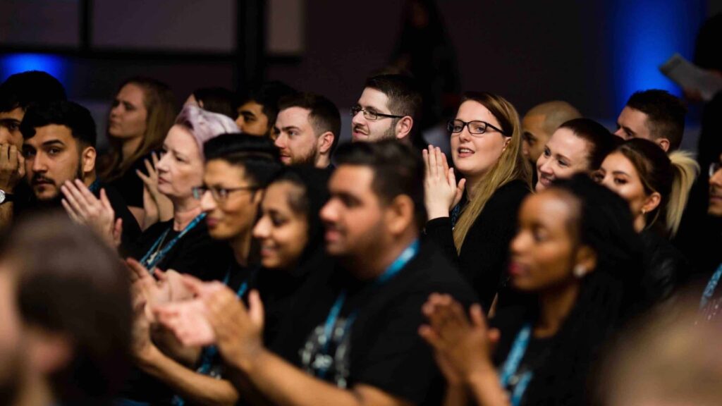 Audience applauding at conference event.