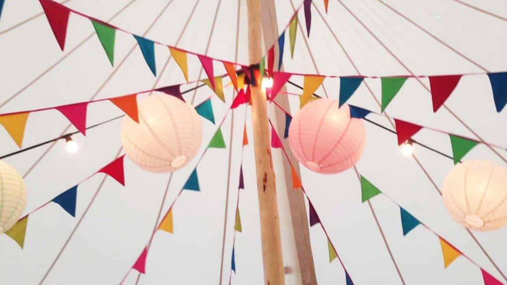 Multi-coloured Easter Bunting Decorations tied to a wooden post in a white marquee.