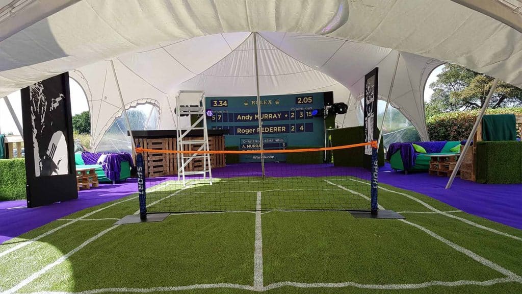 Mini tennis court to hire for Tennis Themed Event production. Featuring Wimbledon leader board. Available to hire London UK