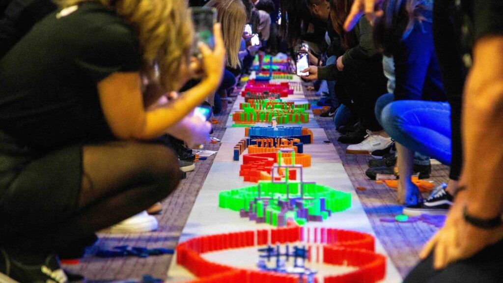 Group of delegates engaging in dominoes team building activity.