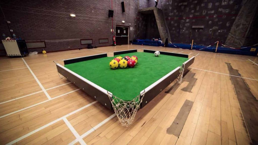 Football pool game set up in the middle of sports hall for football themed event production. Available to hire London UK