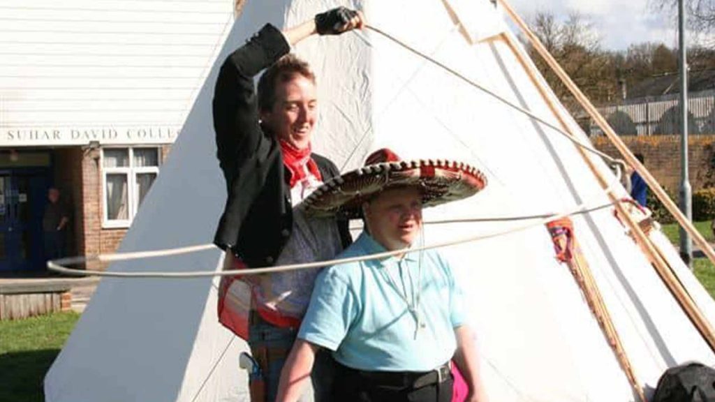 Man lassoing child in cowboy hat as part of entertainment for Wild West Event Production