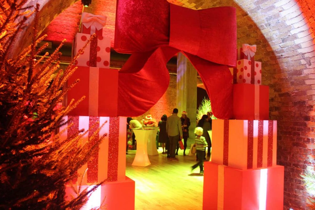 Giant Christmas present archway and Christmas trees surrounding the entrance to a corporate Christmas party as part of our Christmas event theming.