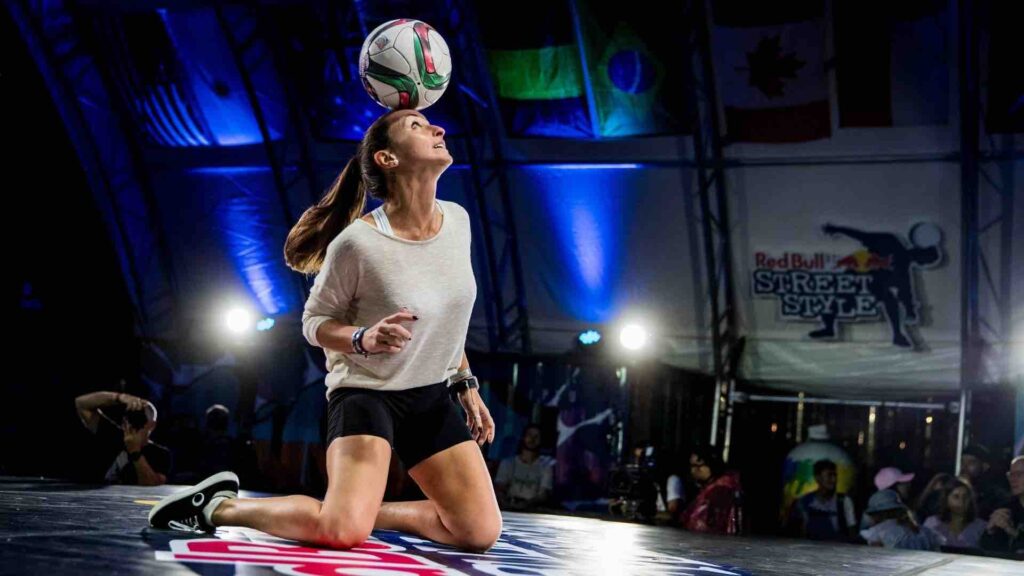 A female football freestyler on-stage at an event