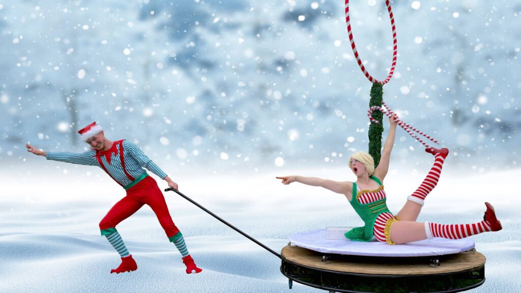 Unique Christmas Elf Circus Show performers being dragged along while posing and laughing