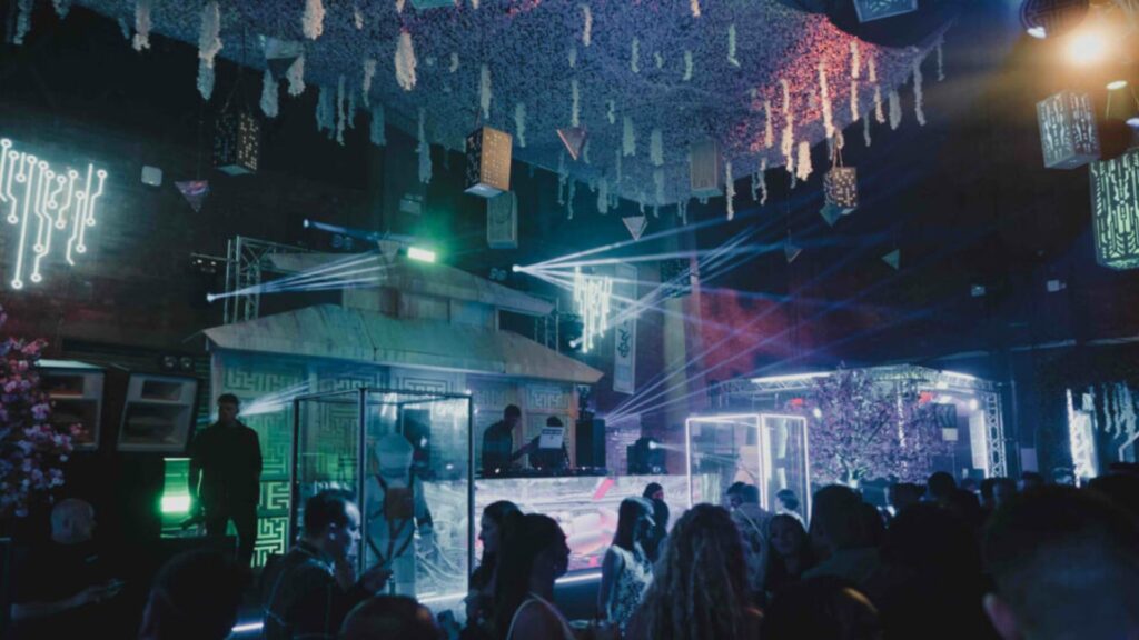 Unique event set and stage design with DJ performer and neon projection lighting.