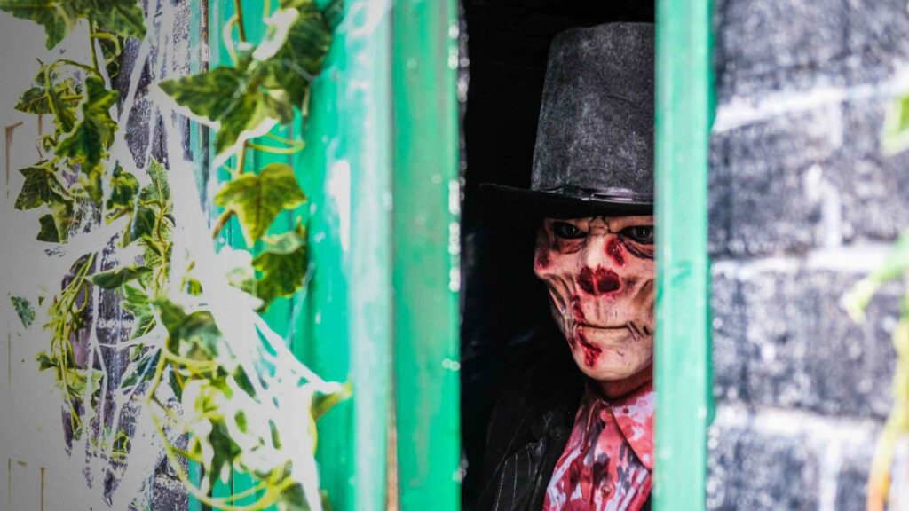 Scary skeleton actor hiding behind door at scare attraction in Southport.