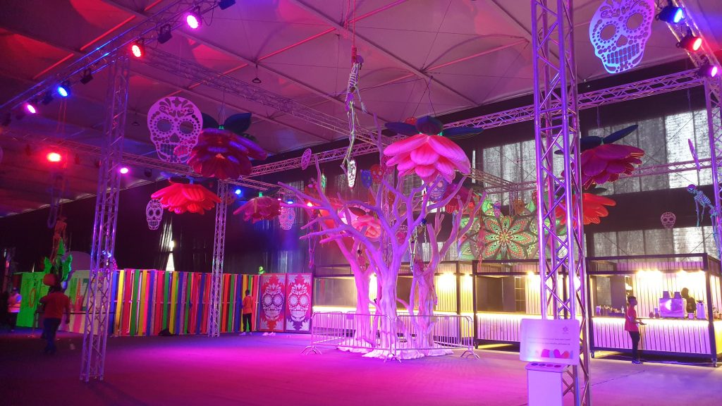 Day of the dead themed area for Saudi Arabia Horror Festival event featuring giant trees and sugar skulls
