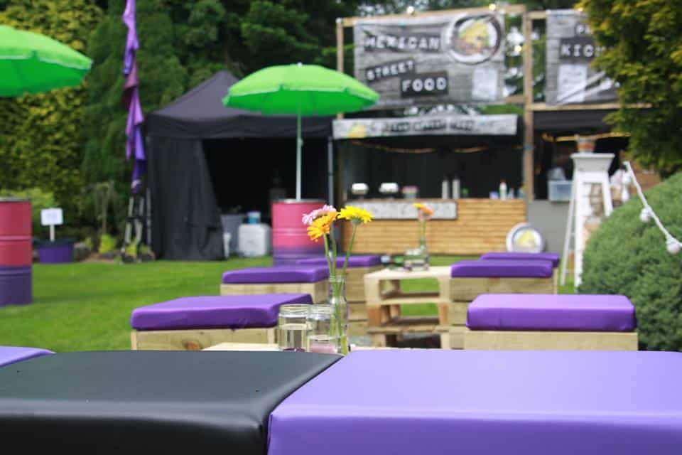 Outdoor Festival Pallet Furniture with black and purple cushioning.