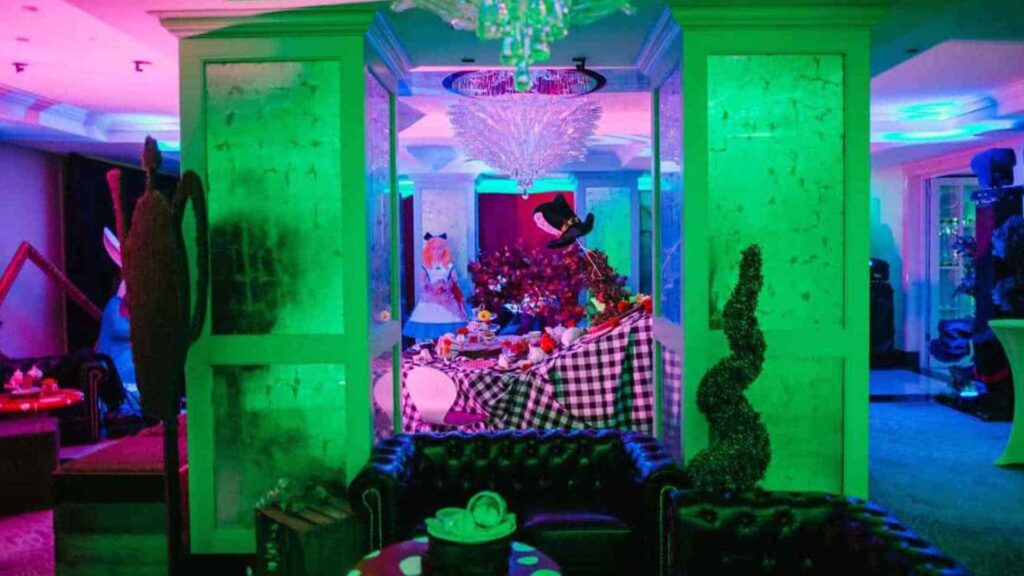 Alice in Wonderland Themed Event Production using bespoke props and green and purple projection lighting.