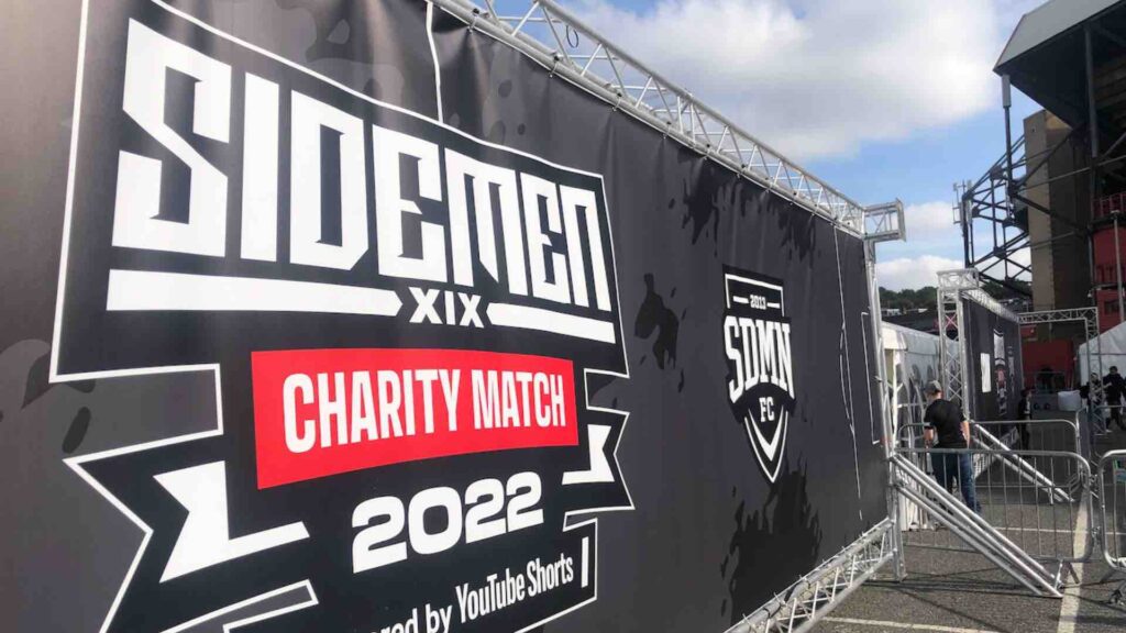 Sidemen Charity Match banner in fan zone area of Sidemen Charity football match.