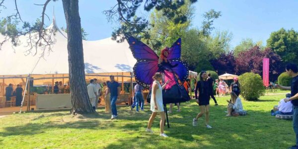 Vibrant butterfly stilt walkers adding flair to a corporate fun day at Magna Carta Island, London.