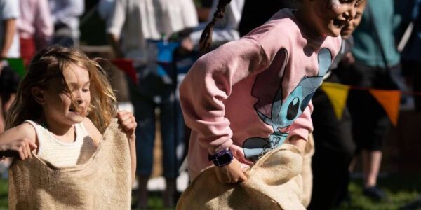 Children-Racing-In-Sack-Race-Activity-At-Fun-Day