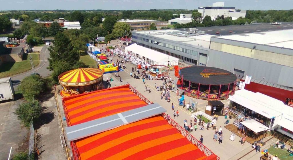 Fairground and circus rides set up in a company car park for a corporate family fun day for BHS.
